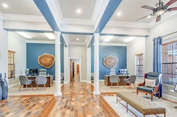 A living room with blue walls and furniture and a ceiling fan